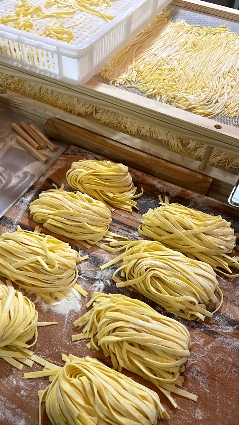 Nidos de fettuccine cortados à mão secando em telas